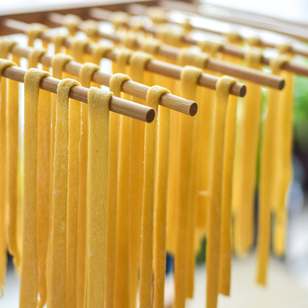 Strands of pasta placed on a drying rack